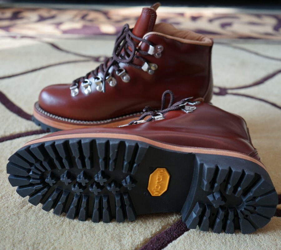 Brown leather boot with a thick black sole on a patterned surface