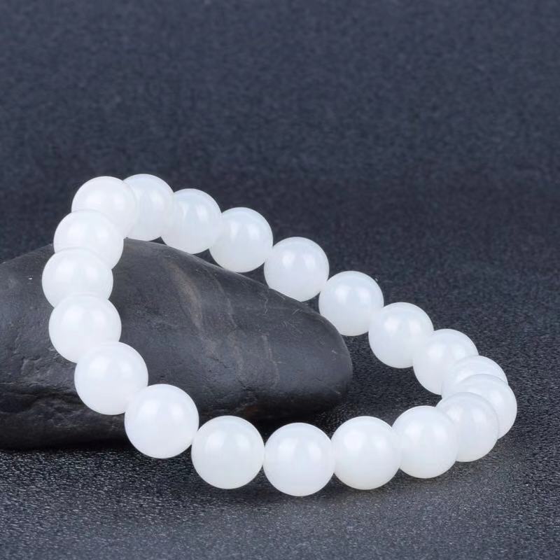 White beaded bracelet on a dark gray background