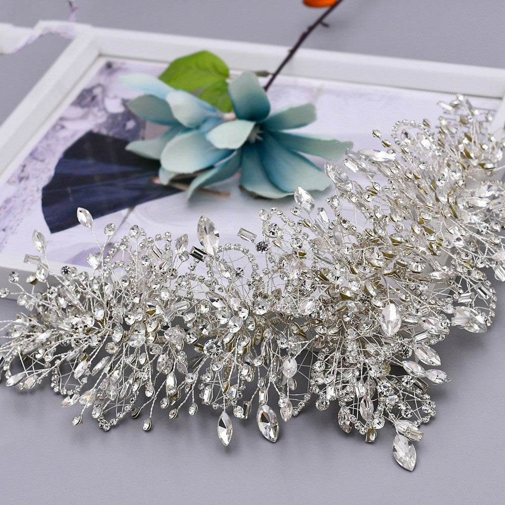 Silver hairpiece with crystal details on a light gray background