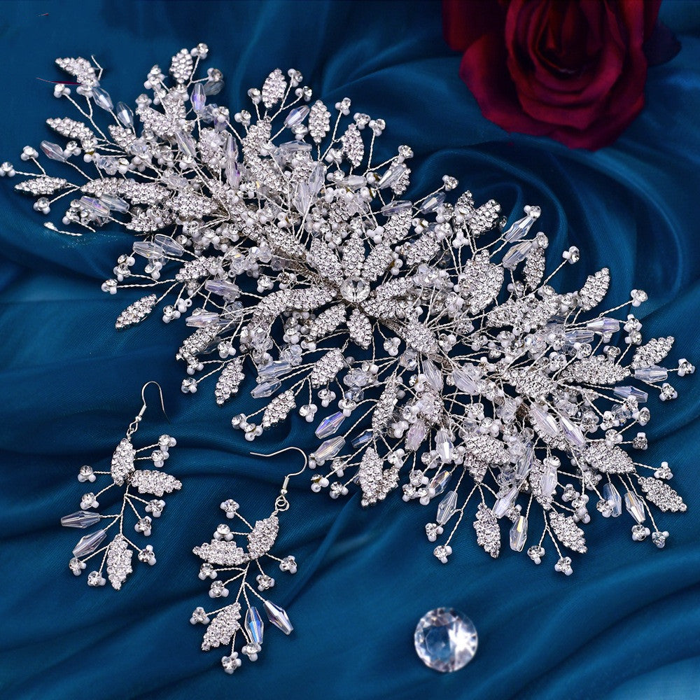 Silver jewelry set with earrings and a hairpiece on blue fabric