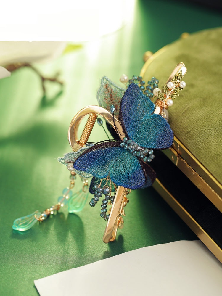 Decorative keychain with butterfly design on a green surface