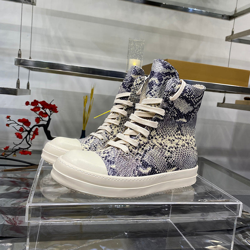 High-top sneakers with a patterned design on a clear stand in a store setting.