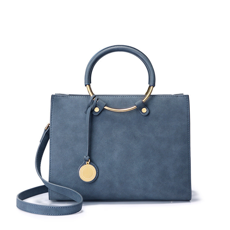 Blue handbag with gold accents on a white background