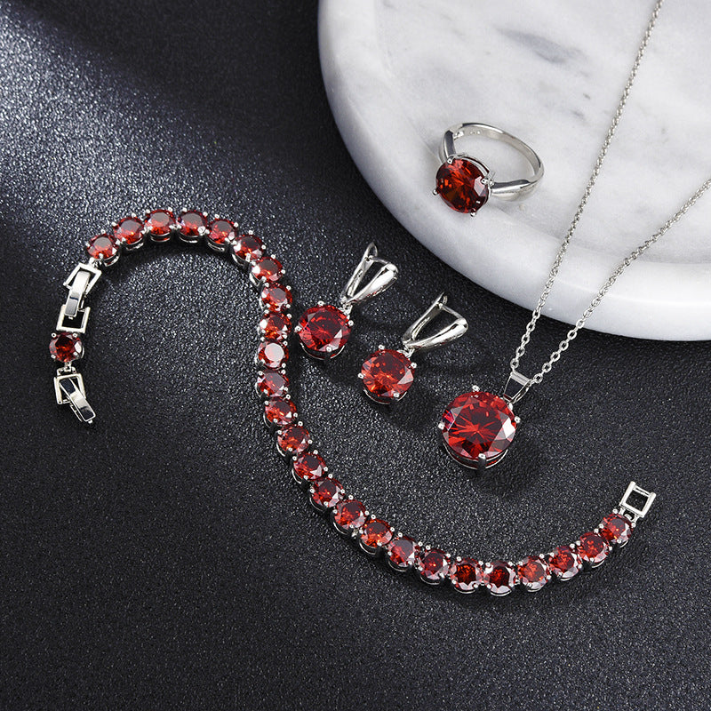 Jewelry set with red gemstones on a dark surface