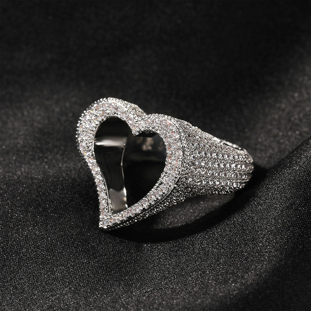 Silver heart-shaped ring with gemstones on a black background