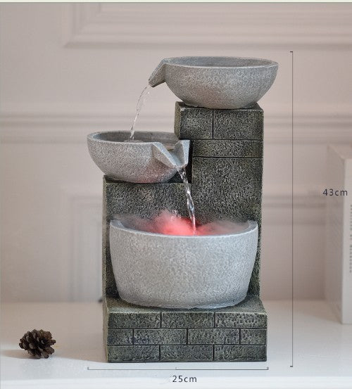 Decorative water fountain with three bowls on a neutral background