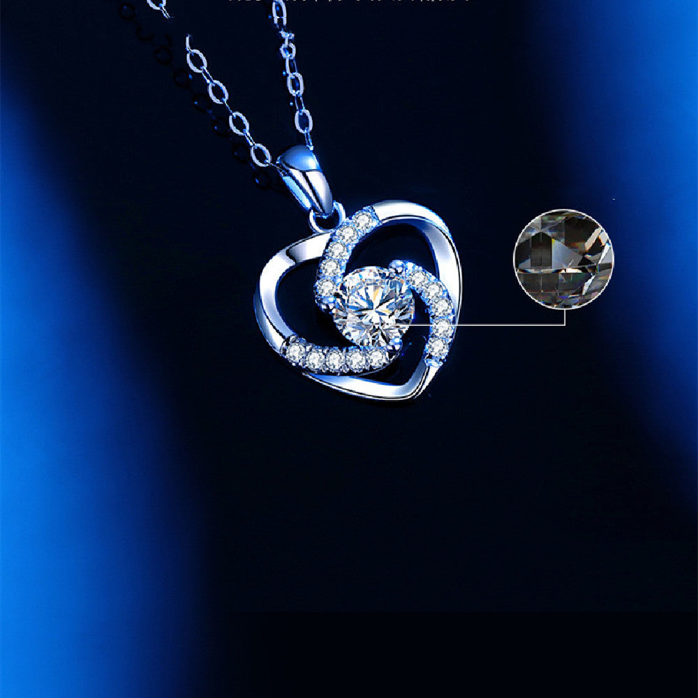 Silver heart-shaped necklace with a diamond on a dark blue background