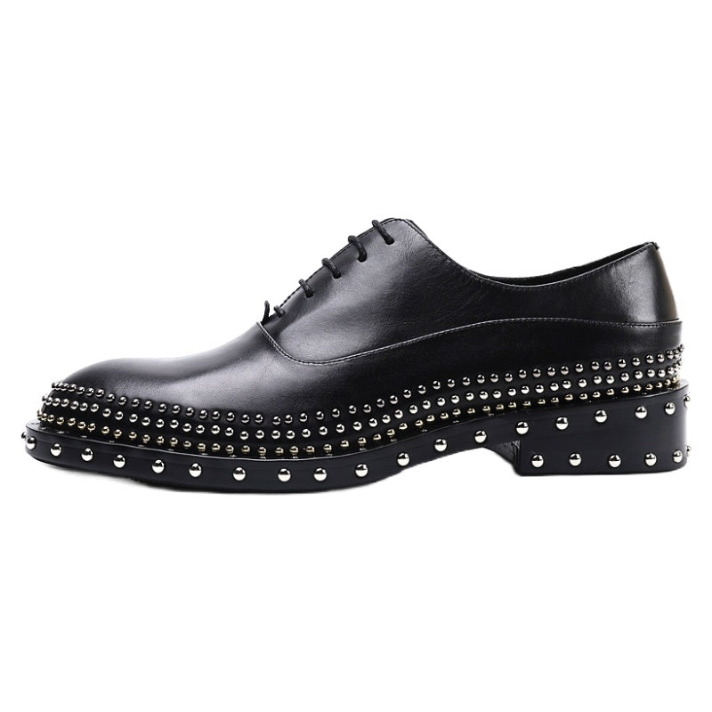 Black leather shoe with studded details on a white background