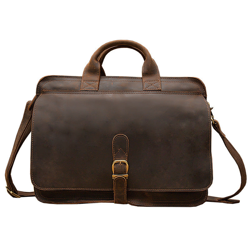 Brown leather briefcase with shoulder strap on a white background
