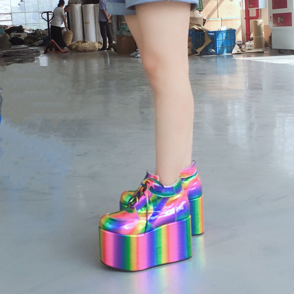 Multicolored platform shoes on a reflective floor with people in the background.