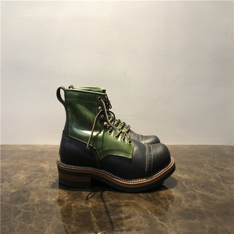 Green and black leather boot on a reflective surface with a neutral background