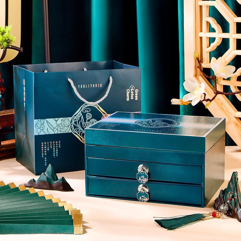 Blue jewelry box with a matching gift bag on a decorative table.