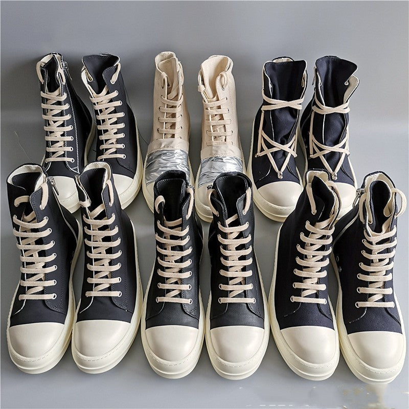 Pair of black and white high-top sneakers on a gray background