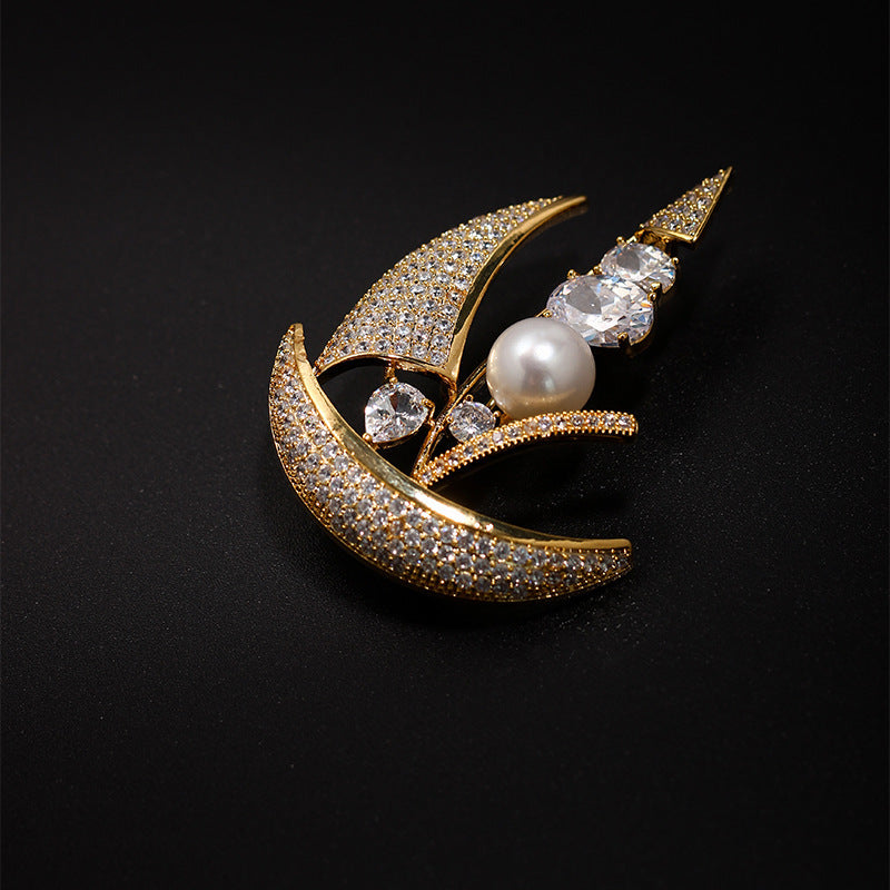 Gold brooch with pearls and crystals on a black background
