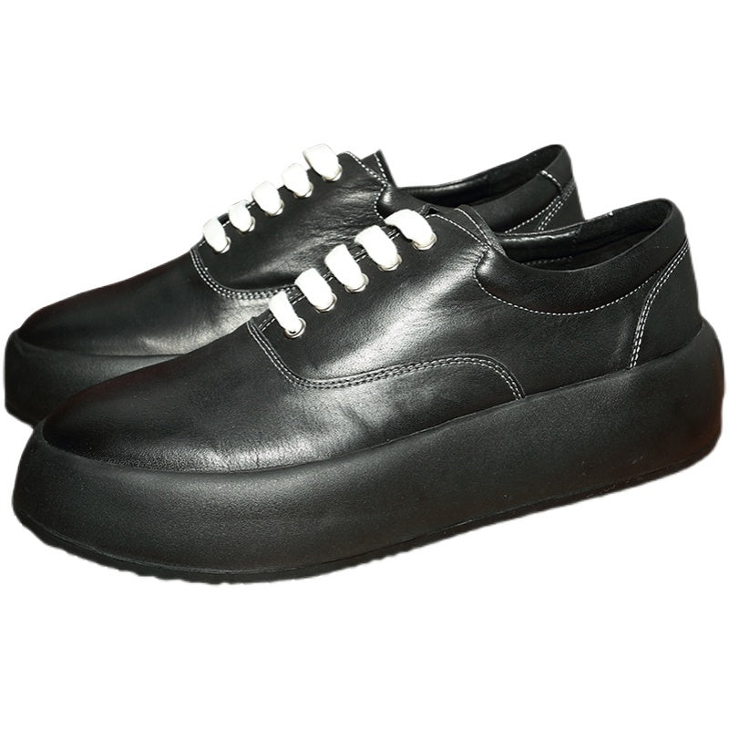 Pair of black leather shoes with white laces on a white background