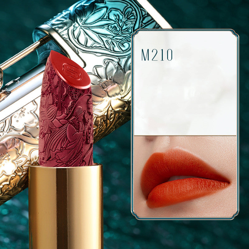 Lipstick with decorative case and color swatch on a teal background