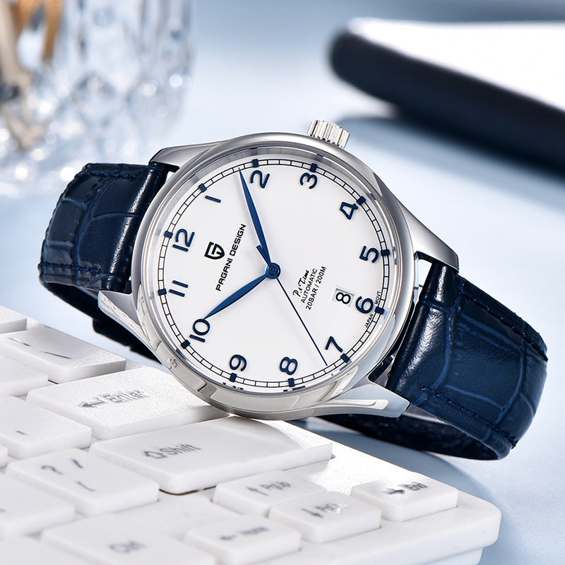 Watch with blue strap on a white keyboard against a blurred background