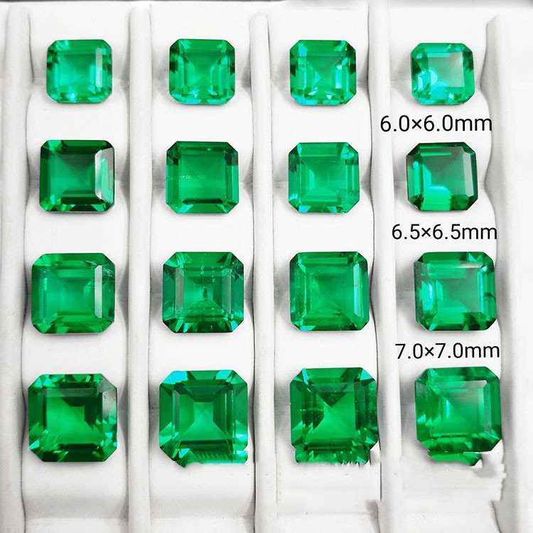 Green square-cut gemstones of different sizes on a white background