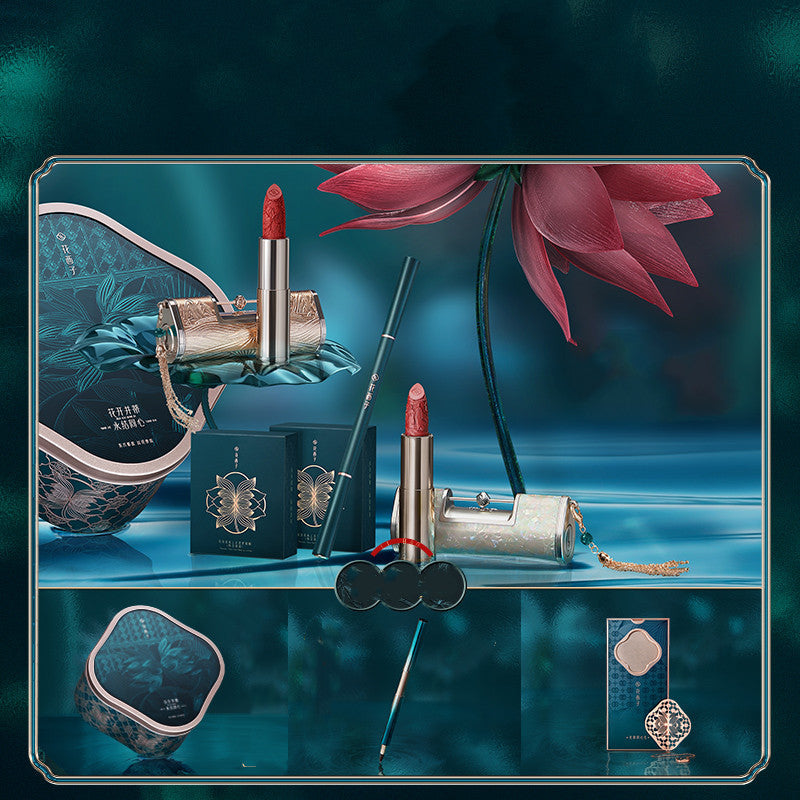 Makeup products including lipsticks and a compact with a pink flower on a dark blue background
