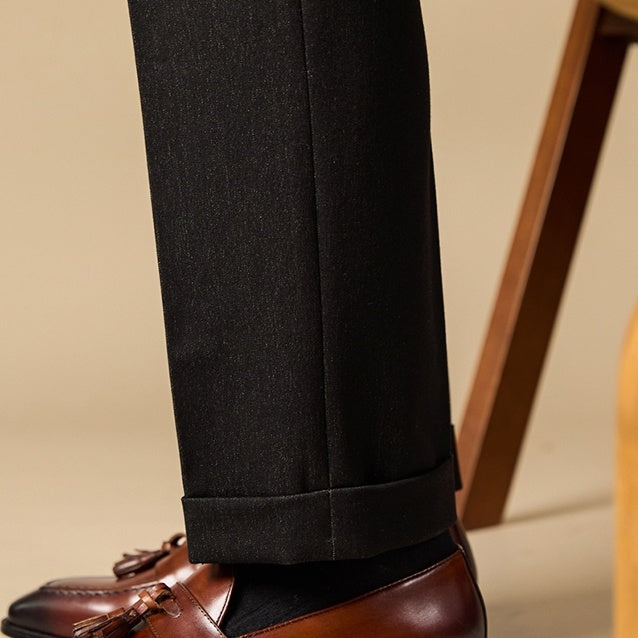 Black pants with brown shoes on a beige background