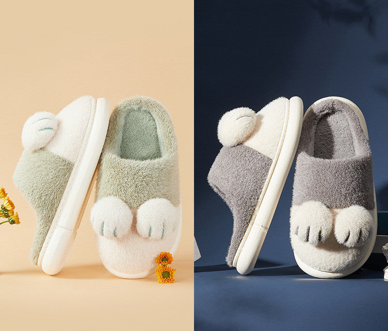 Pair of plush slippers with paw-like toes on a beige and blue background