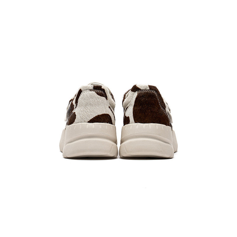 Pair of brown and white sneakers on a white background