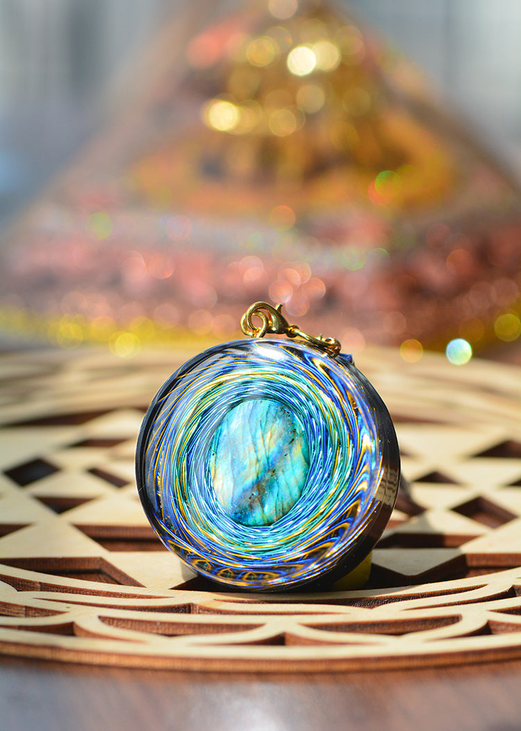 Colorful glass pendant on a woven surface with blurred background