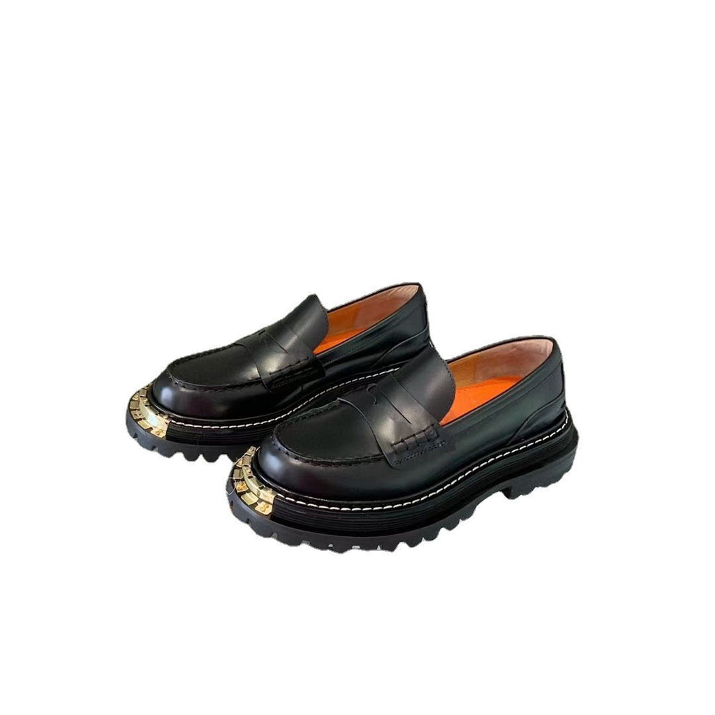 Pair of black loafers with gold accents on a white background