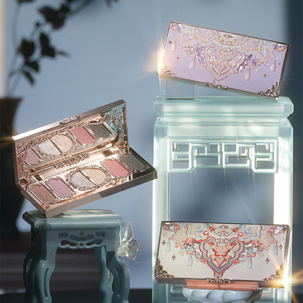 Makeup palettes with decorative cases on a reflective surface
