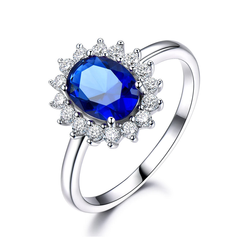 Silver ring with a blue gemstone and diamond accents on a white background