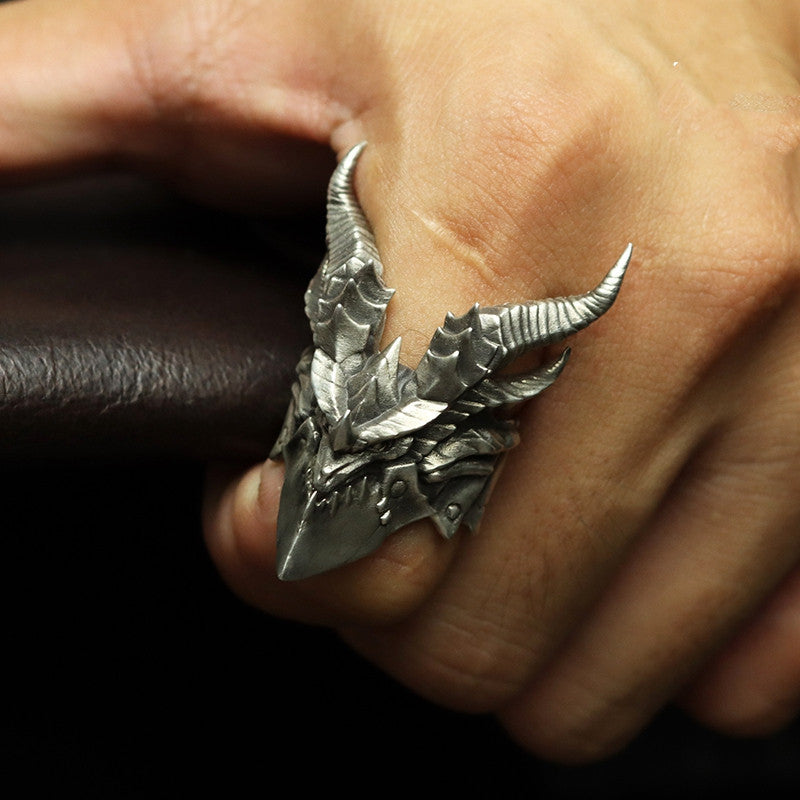 Silver dragon scale ring on a finger with a dark background