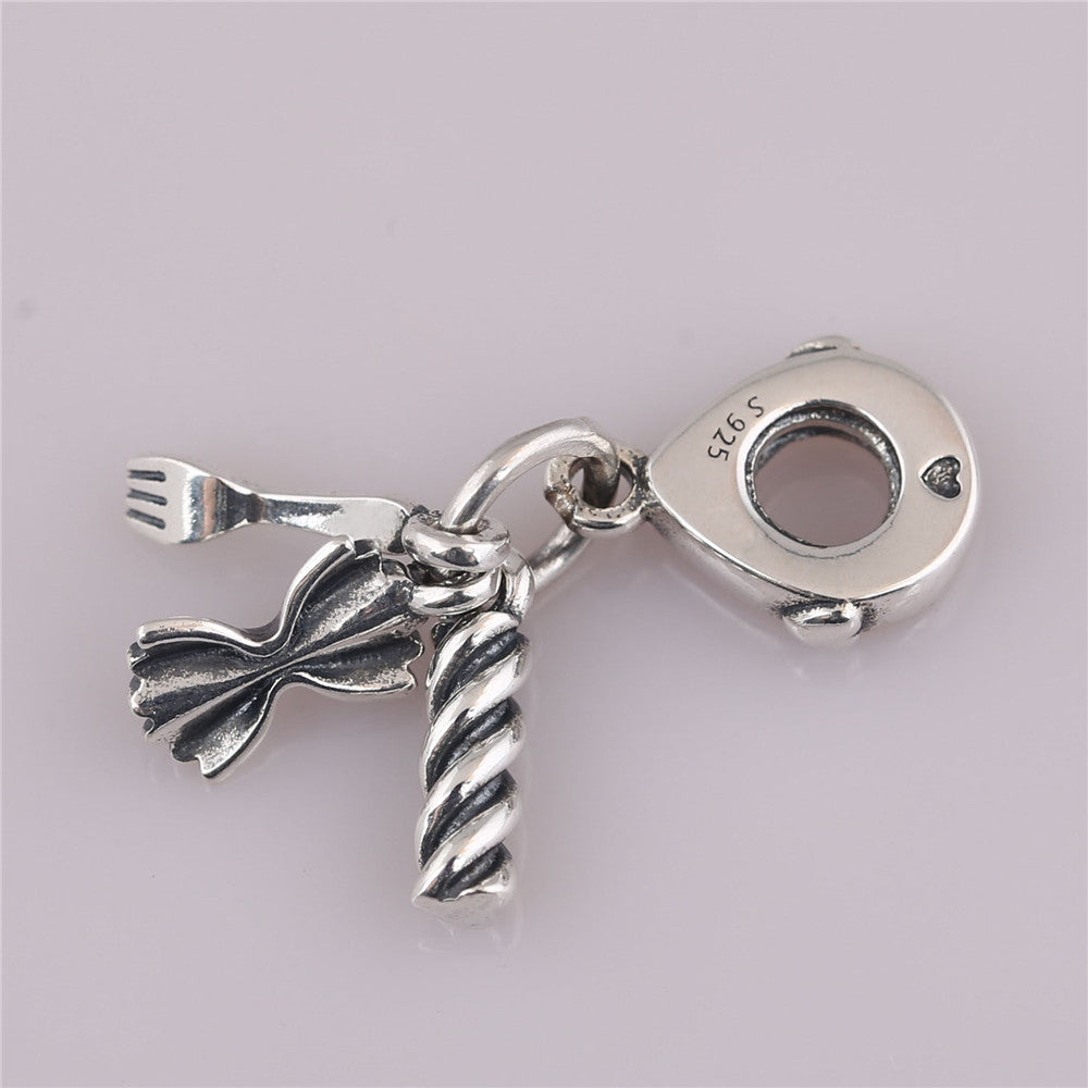 Silver charm with fork, knife, and heart design on a light gray background