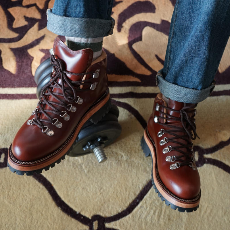 Brown leather boots with laces on a patterned carpet