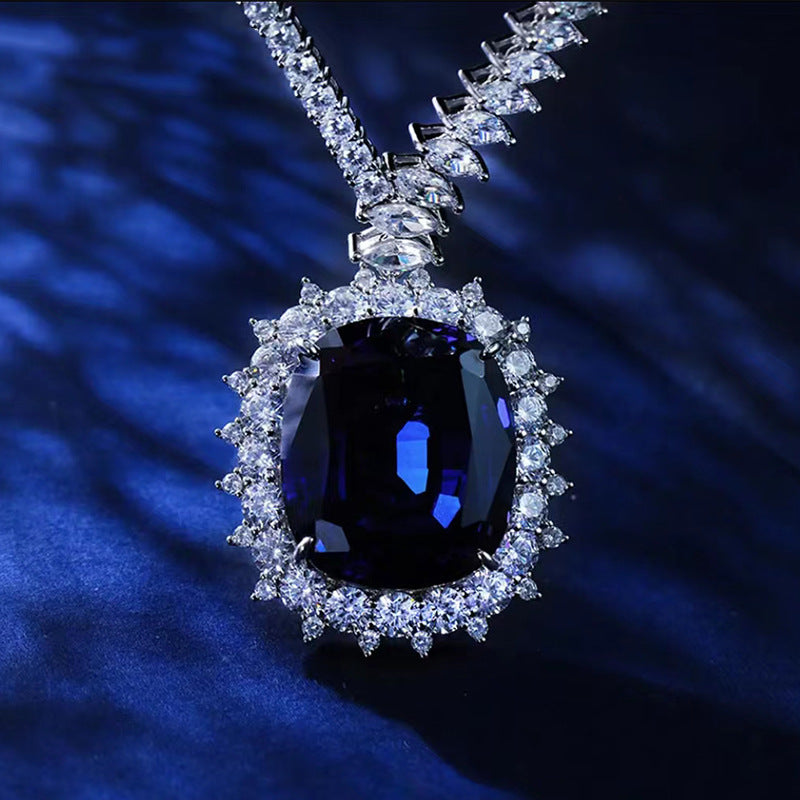 Diamond necklace with a central blue gemstone on a dark blue background
