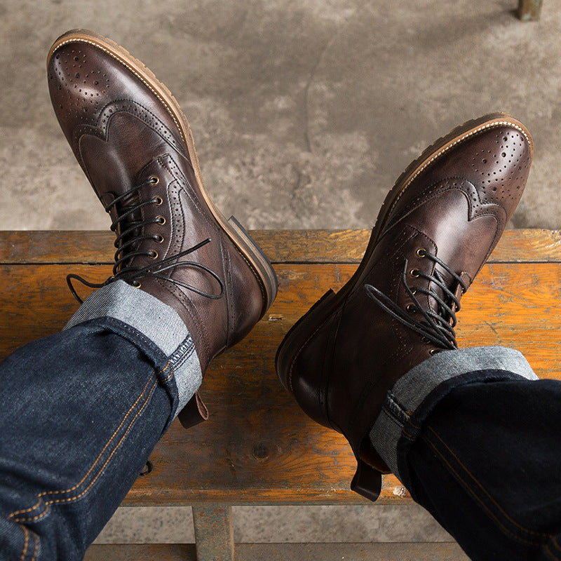 Brown leather shoes with laces on a wooden bench against a concrete wall.