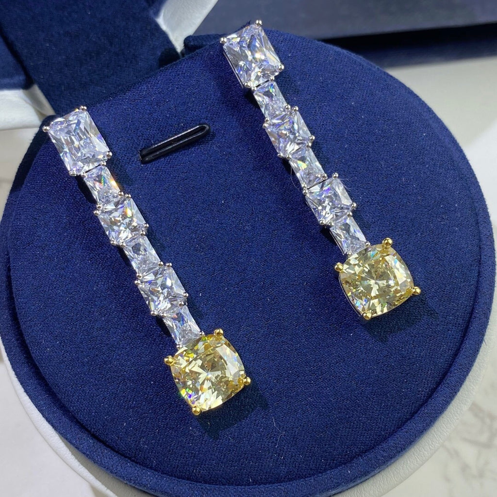 Pair of diamond earrings on a blue cushion