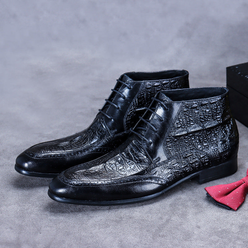 Black leather dress shoes with textured design on a gray surface, accompanied by a red bow tie.