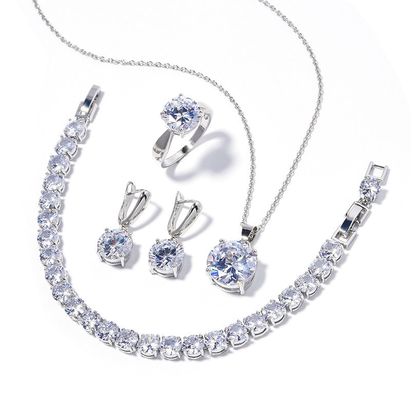 Silver jewelry set with necklace, earrings, and ring on a white background
