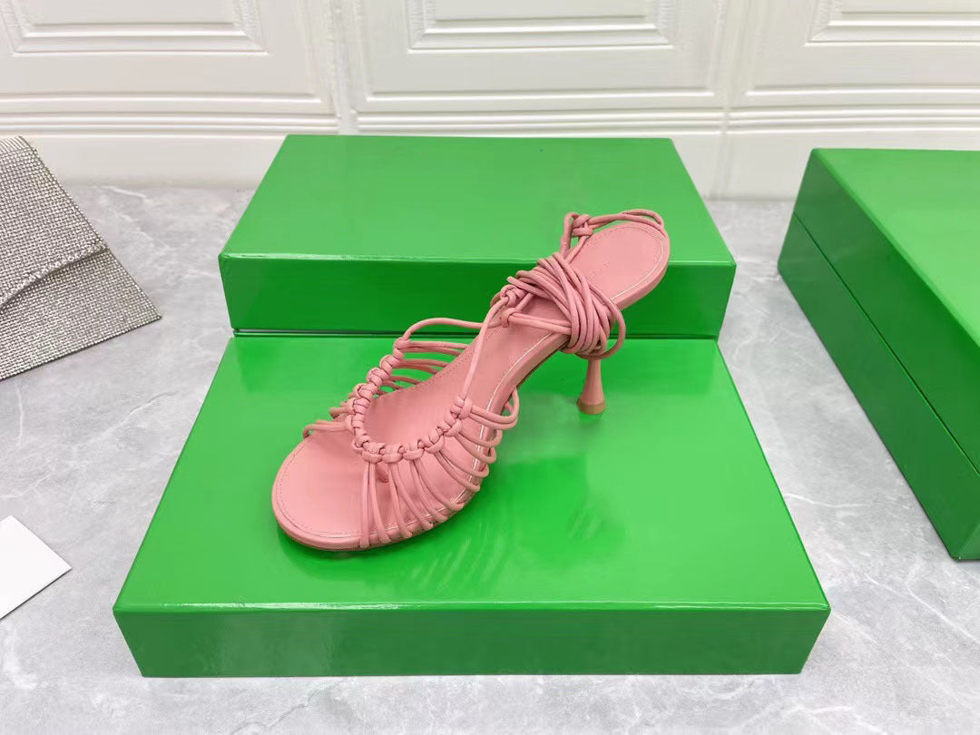 Pink sandal on a green box with a white textured background