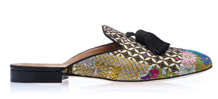 Colorful embroidered slipper with tassel on a white background