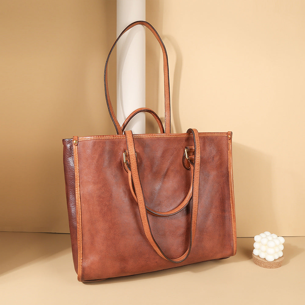 Brown leather tote bag on a beige background