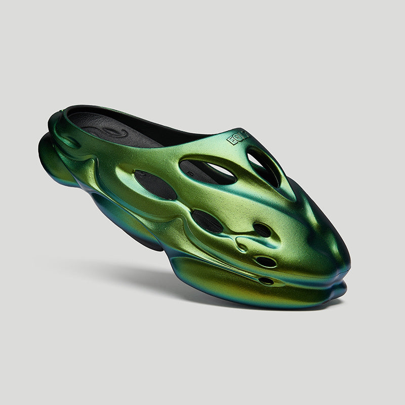 Green and black sandal on a light gray background