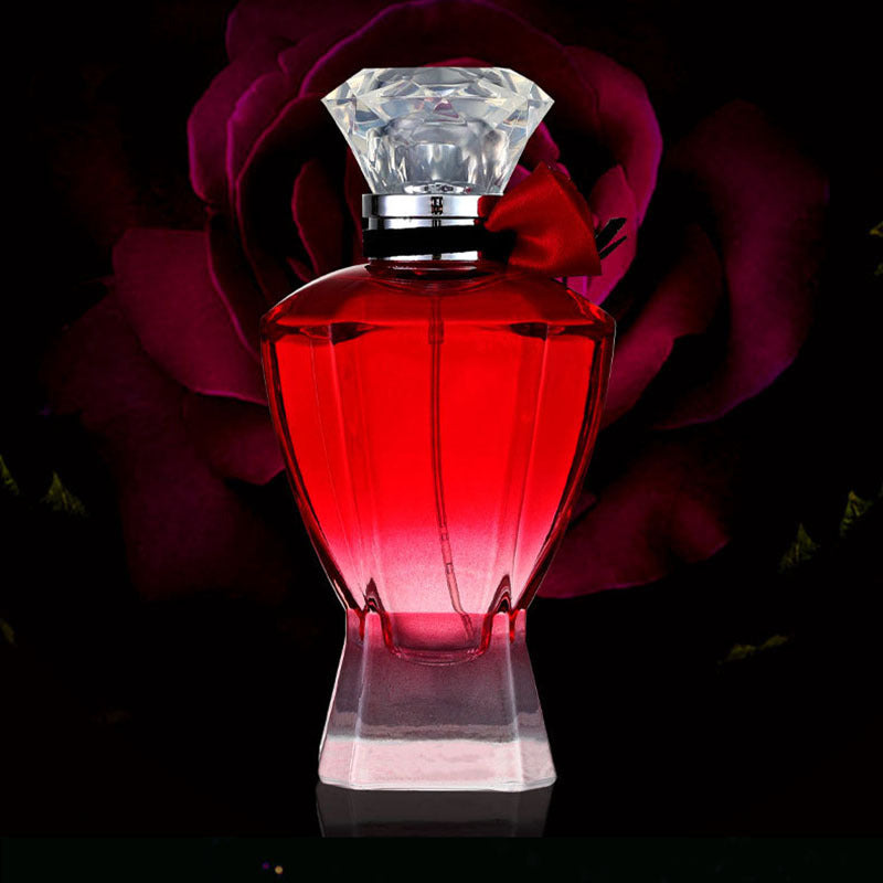 Red perfume bottle with a diamond-shaped cap against a dark background