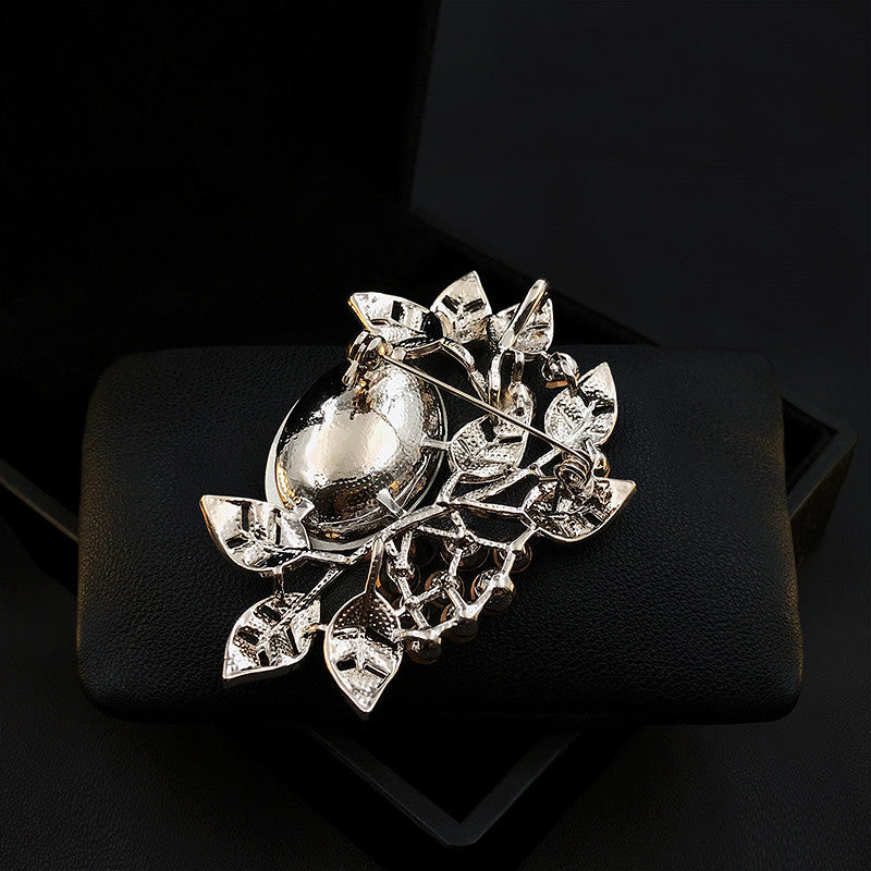 Silver brooch with leaf design on a black background