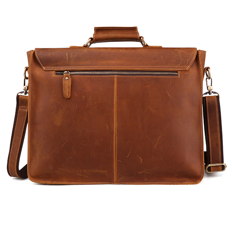 Brown leather briefcase with shoulder strap on a white background