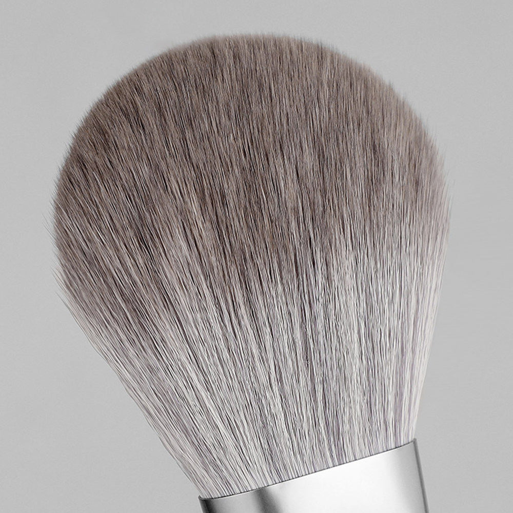 Makeup brush with gray bristles on a light gray background