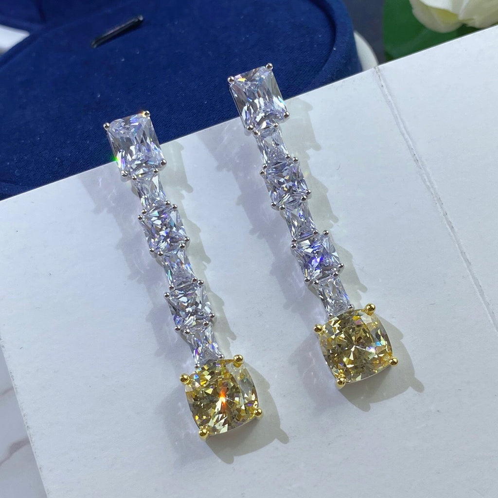 Pair of diamond earrings on a white surface with a blue background