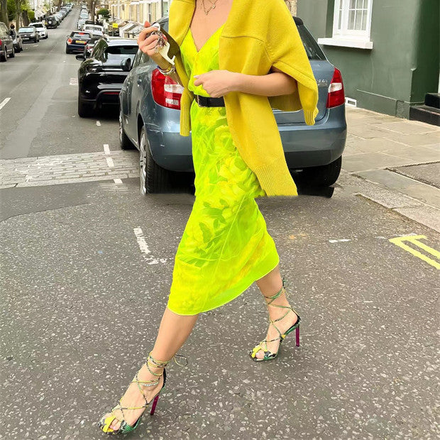 Person wearing a bright yellow outfit walking on a street.
