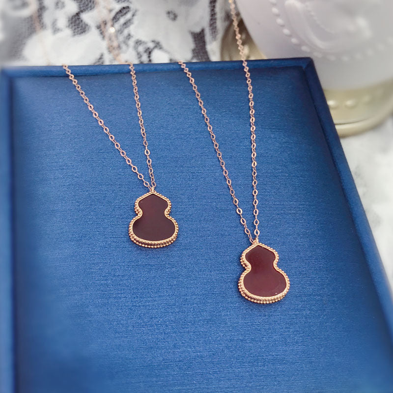 Two necklaces with pendant pendants on a blue surface