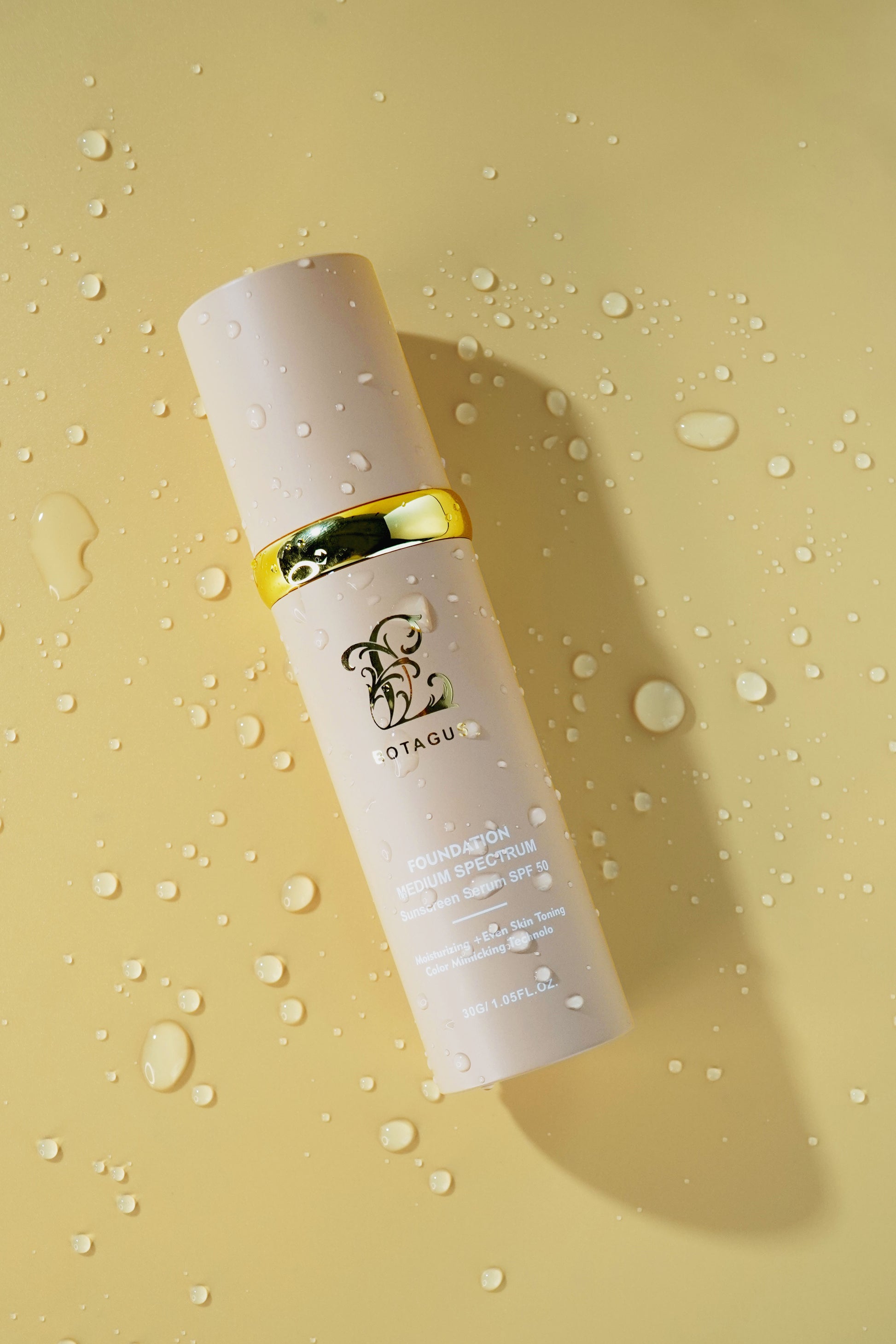 Skincare bottle with gold cap on a beige background